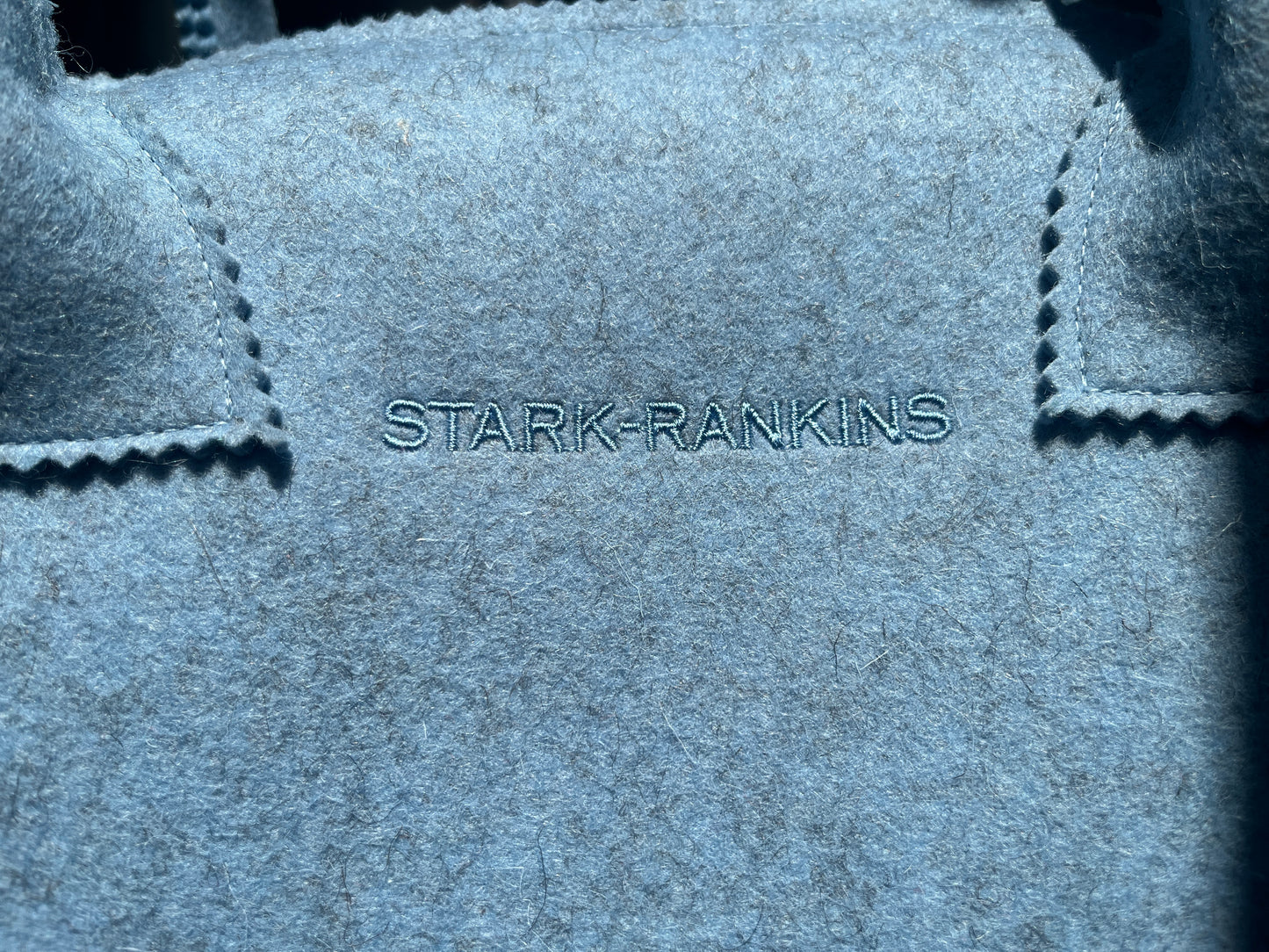 Close-up of a blue fabric with "STARK-RANKINS" stitched in the center.