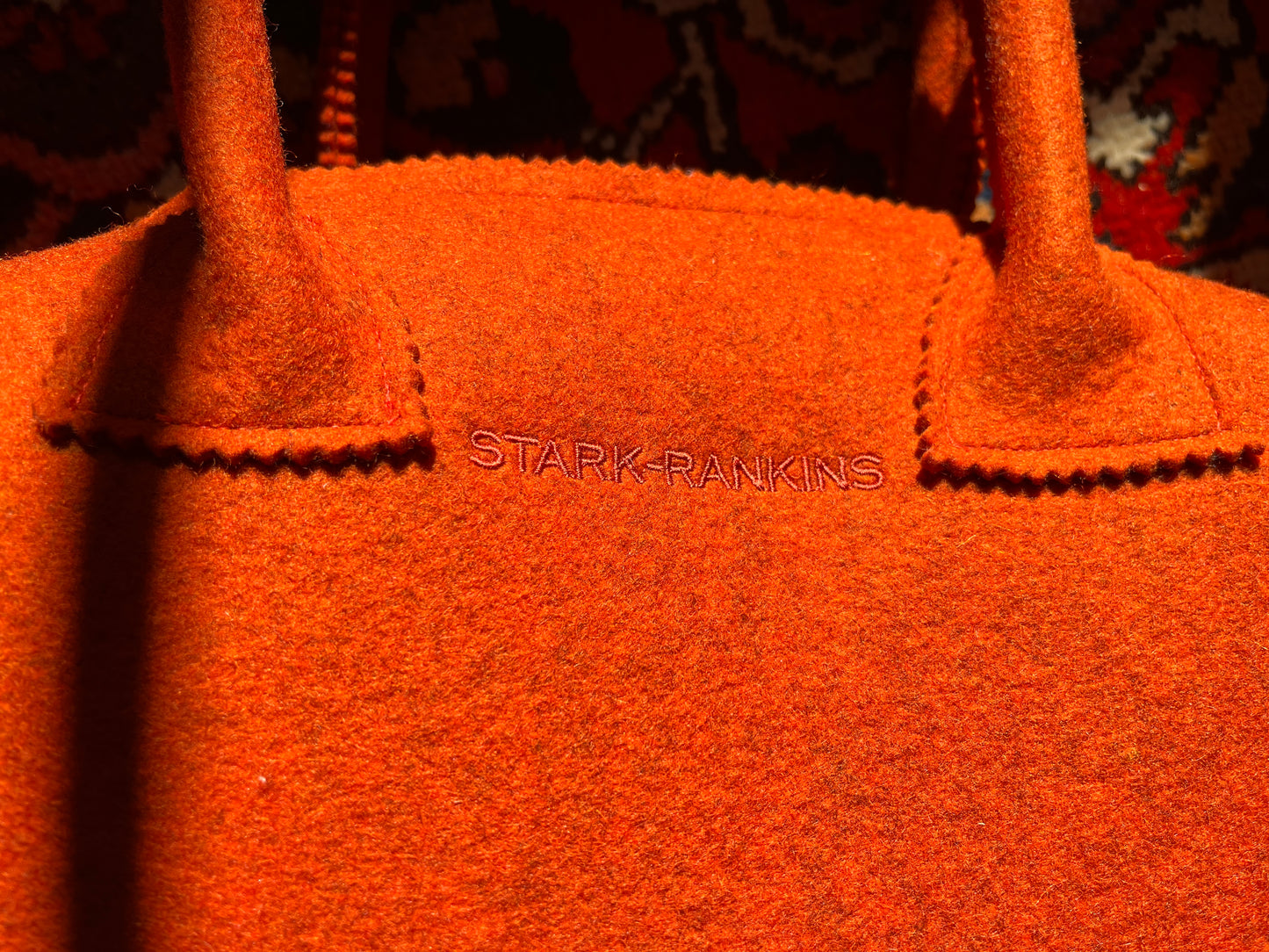 Close-up of an orange felt bag with the words "STARK RANKINS" embroidered on it.